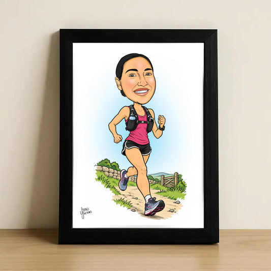 A framed caricature portrait print of a woman running outdoors, shown leaning against a light beige wall on a wooden surface. The artwork is inside a black frame with a white mat and features a colorful cartoon runner in pink and black athletic wear.