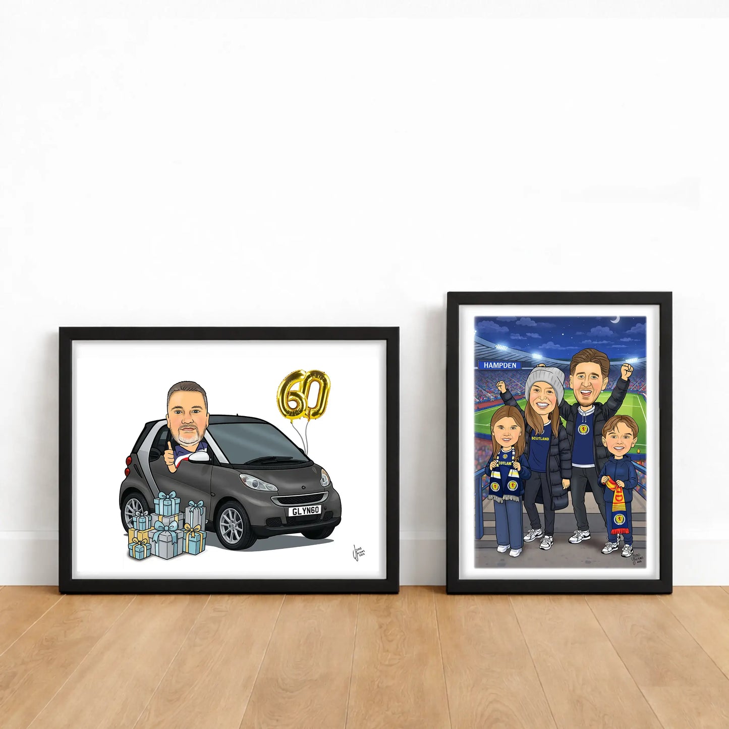 Two framed caricatures on a wooden floor against a white wall.