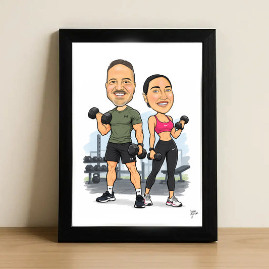 A framed custom caricature illustration of a man and a woman lifting dumbbells in a gym, displayed on a light wood surface against a beige wall.
